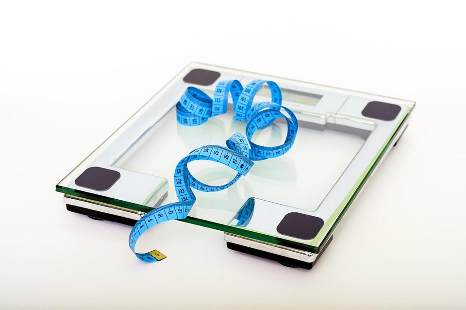 A bathroom scale with measuring tape for body composition