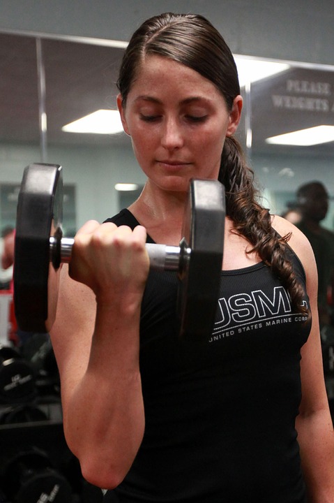 A woman lifting weights in a gym to get fit